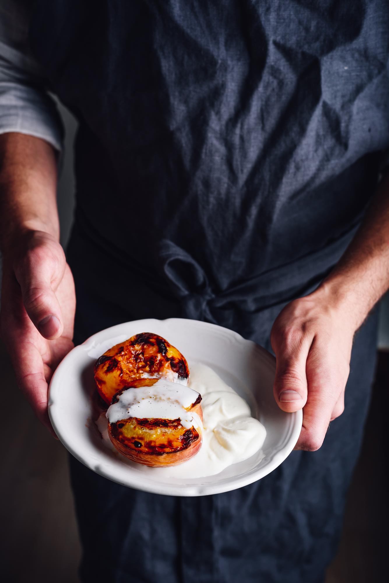 Chef demonstrating plating technique in elegant kitchen